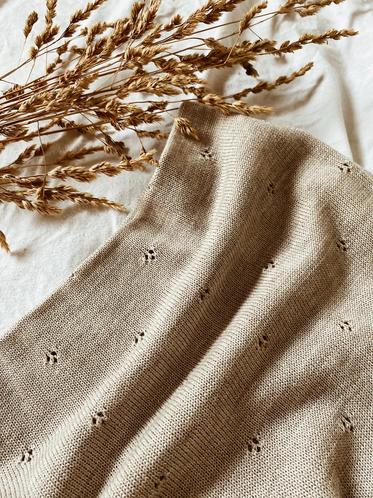 Feine Strickdecke von Blätterschming mit Trockengräsern.